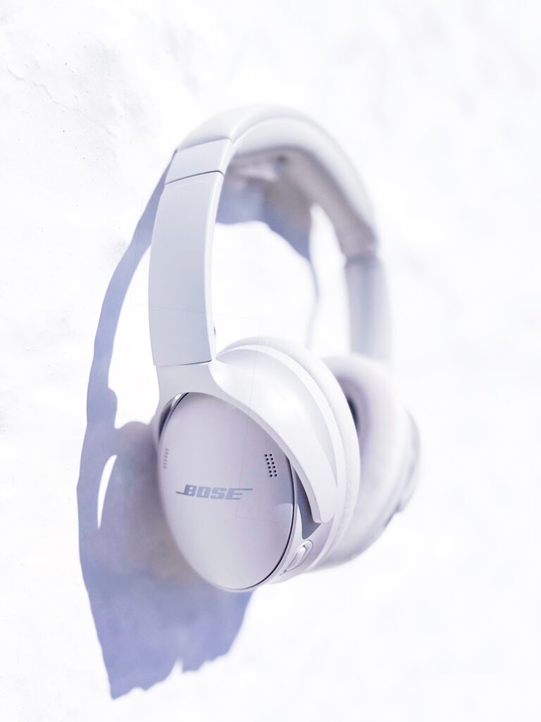 Weiße Bose QuietComfort 45 Kopfhörer an einer weiß getünchten Wand hängend