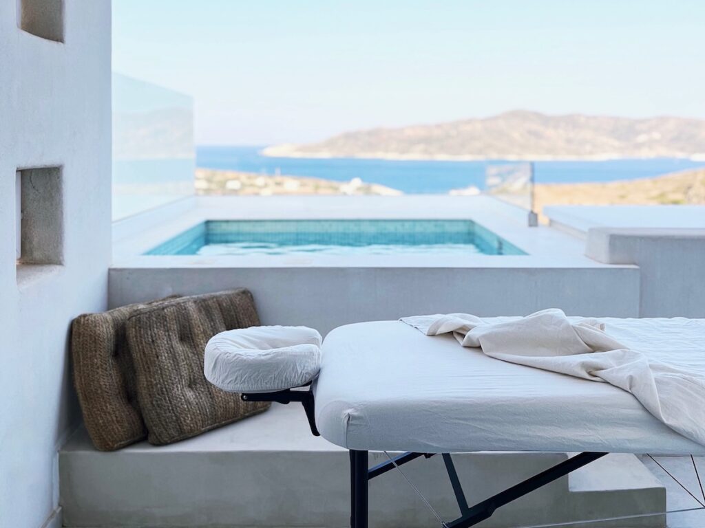 Massage setup on a peaceful balcony overlooking turquoise waters on Kimolos, Greece