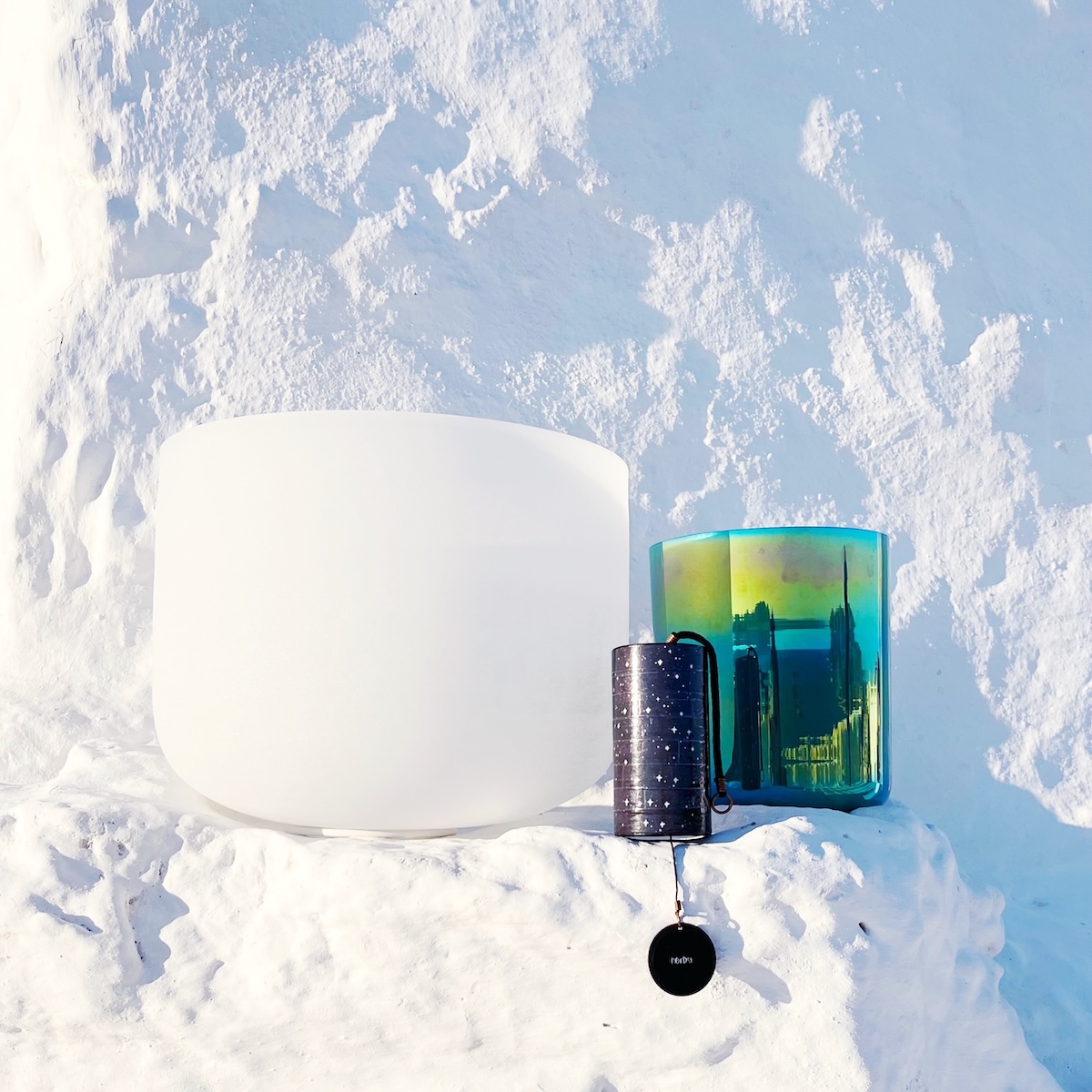 Crystal singing bowls and Zaphir chime on white Cycladic stone, part of Jenny’s Cosmic Sounds Healing sessions in Greece