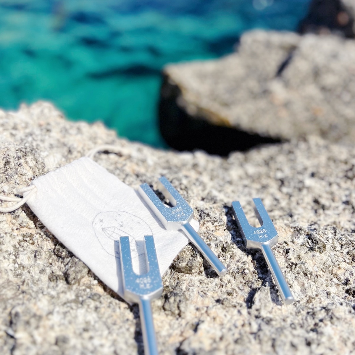 Tuning forks on the rocks by the Aegean Sea, used in Cosmic Sounds Healing sessions by Jenny on Kimolos Island, Greece