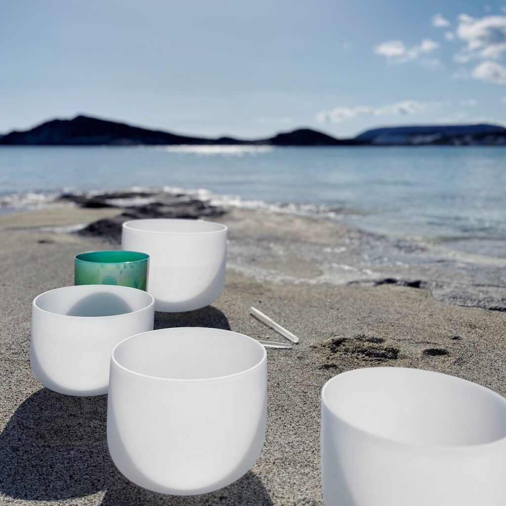 Crystal singing bowls on the beach in Kimolos during a Sound Bath in Greece