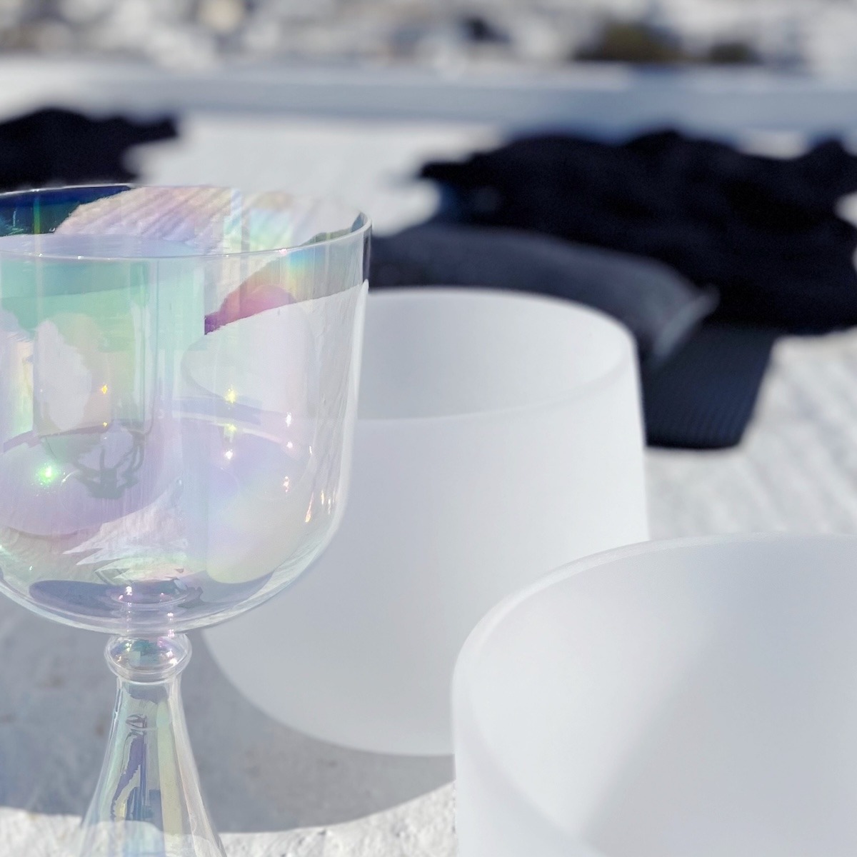 Crystal singing bowls on a beach during an outdoor Sound Bath on Kimolos Island in Greece